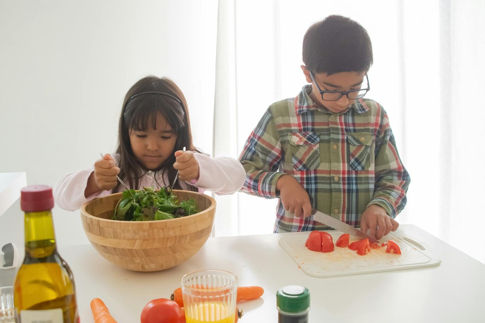Two children prepare a healthy vegetable salad together at home, mixing ingredients with enthusiasm.